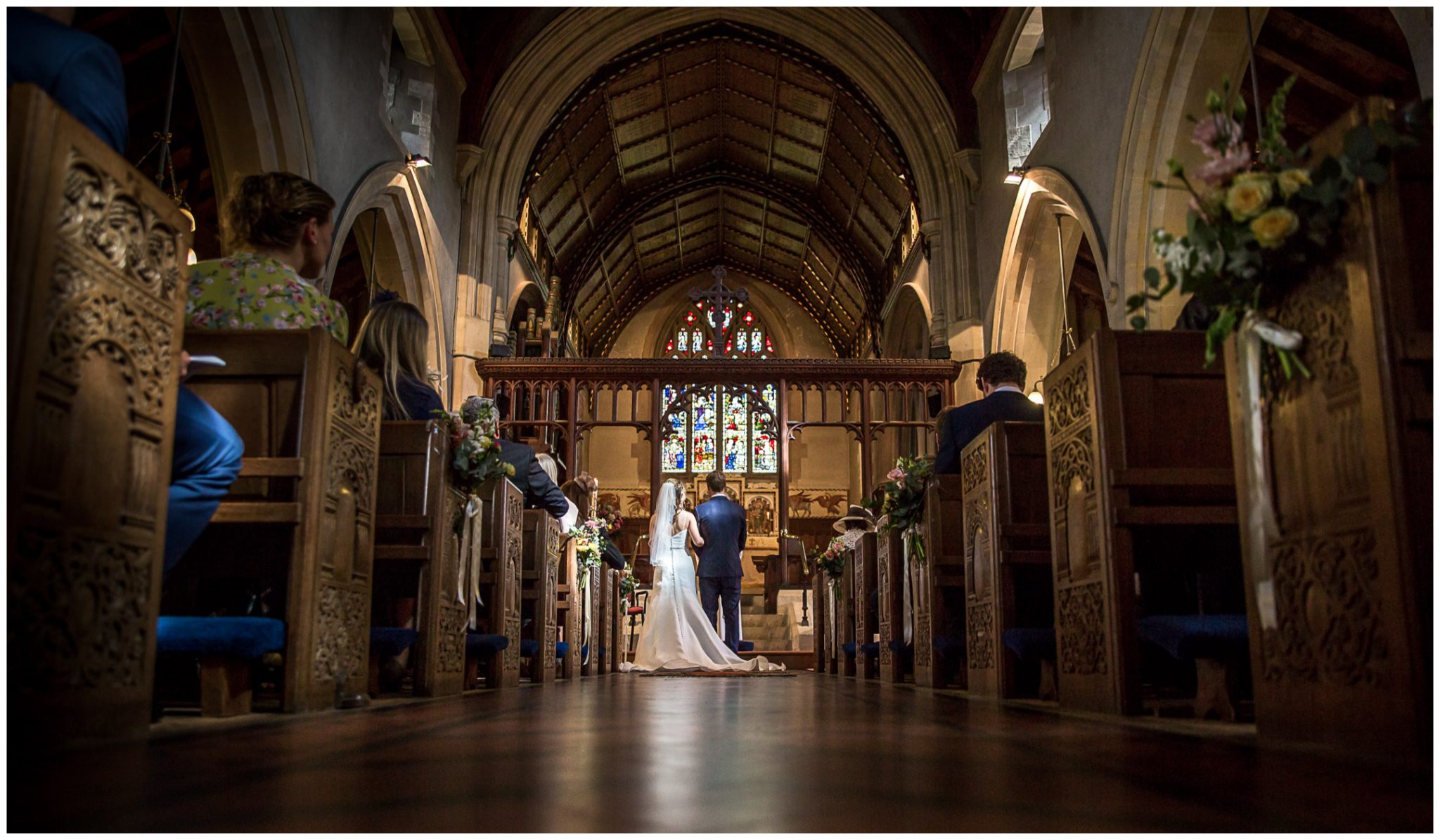 Colour photo of bride and groom stood at the end of the aisle