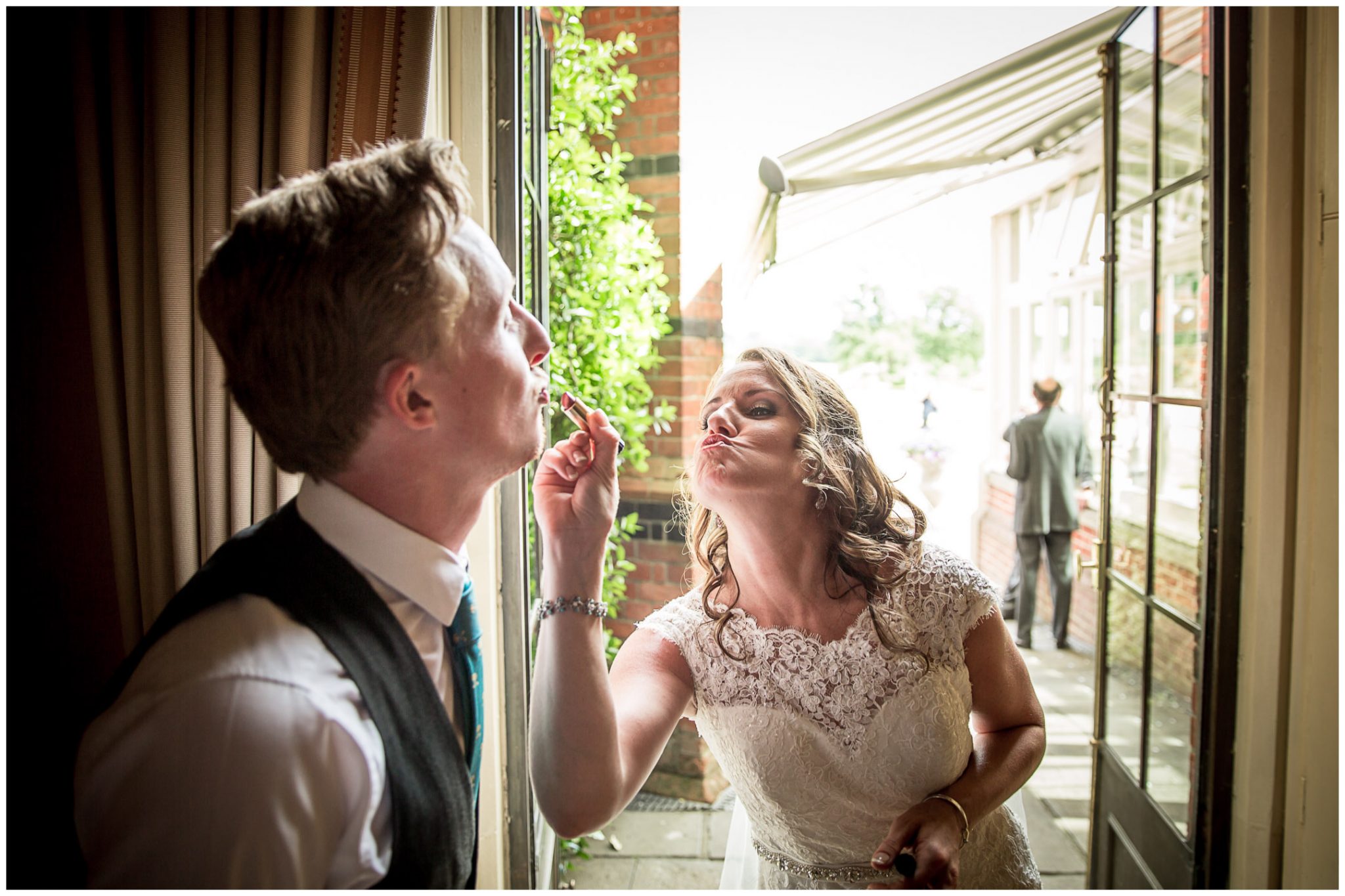 The bride applies a few finishing touches to the wedding coordinator's makeup