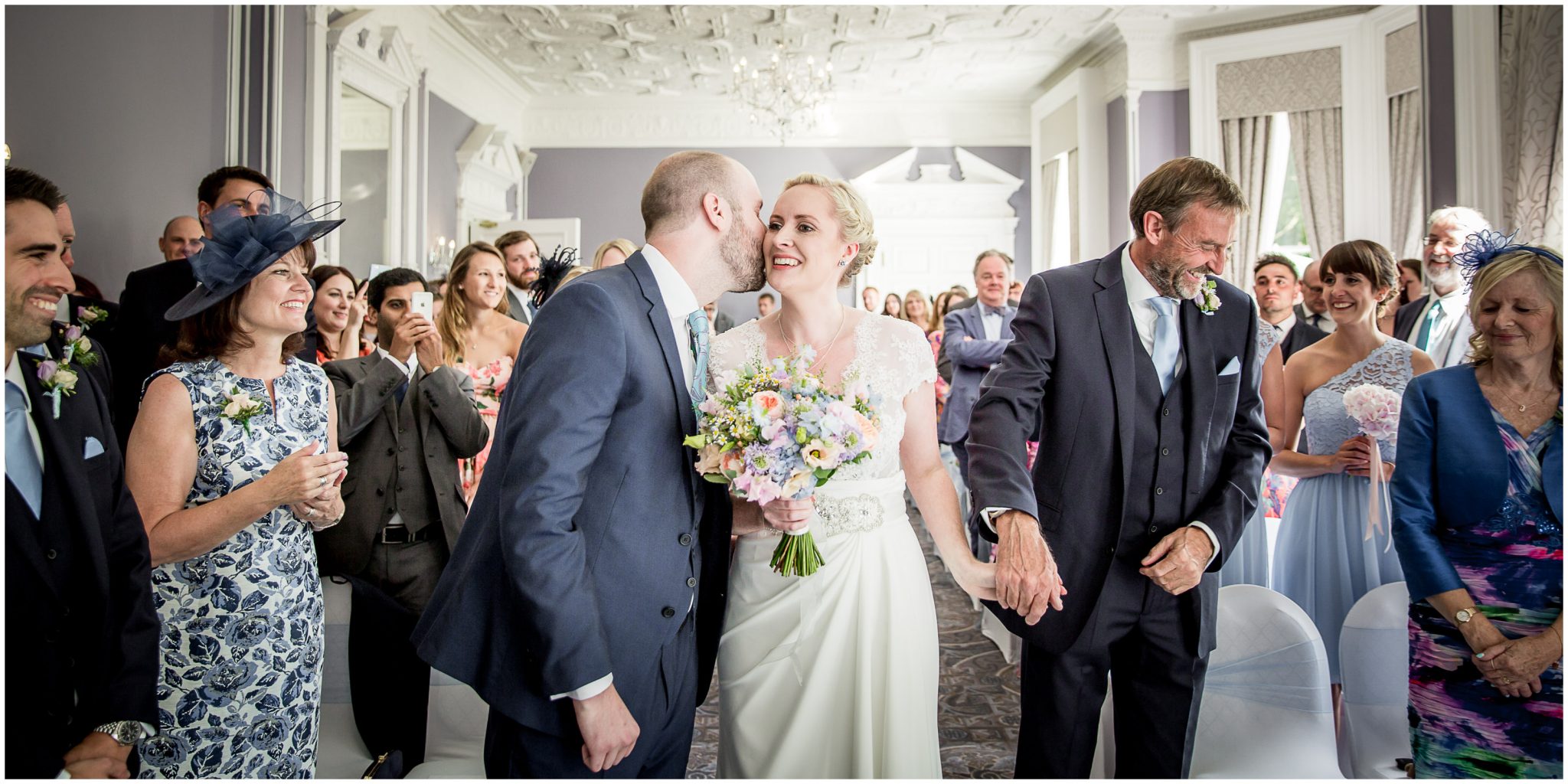 Oakley Hall wedding photography bride and groom kiss at start of marriage ceremony