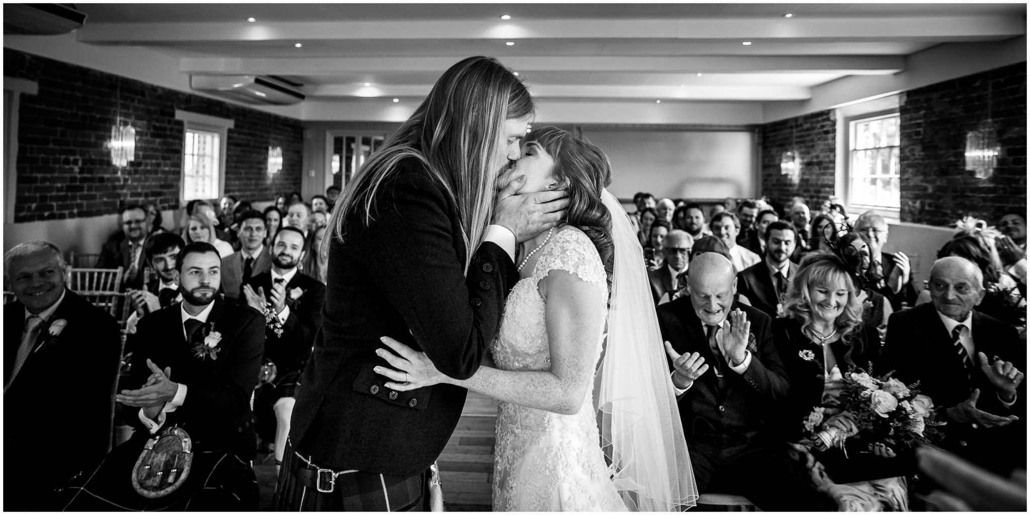 Bride and groom first kiss black and white