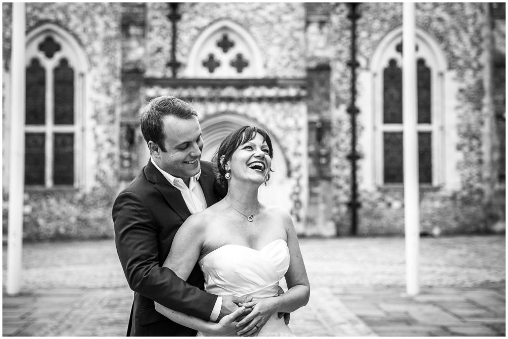 Black and white portrait photo with wedding couple laughing
