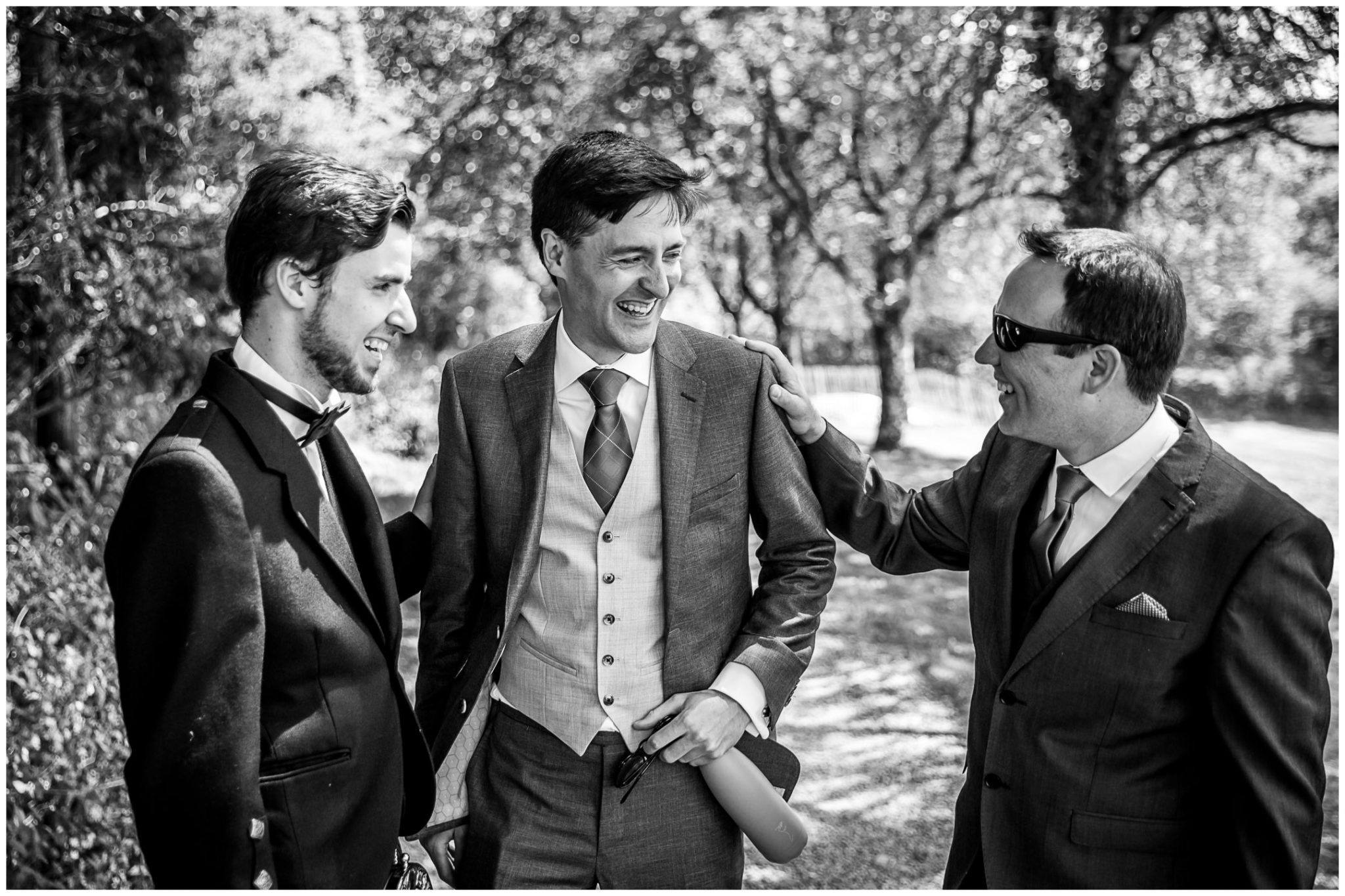 Groom laughing with groomsmen candid photography