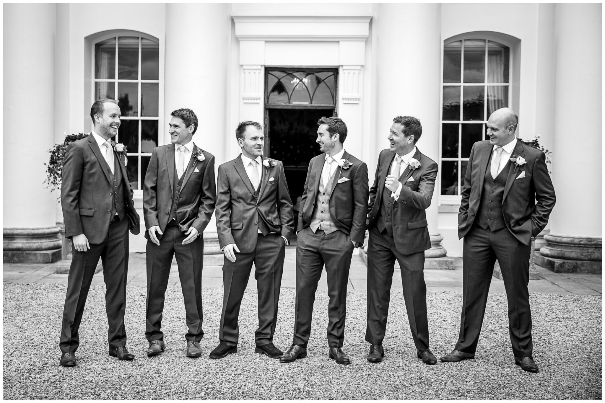 Black and photo of groom and best men stood outside Avington wedding venue
