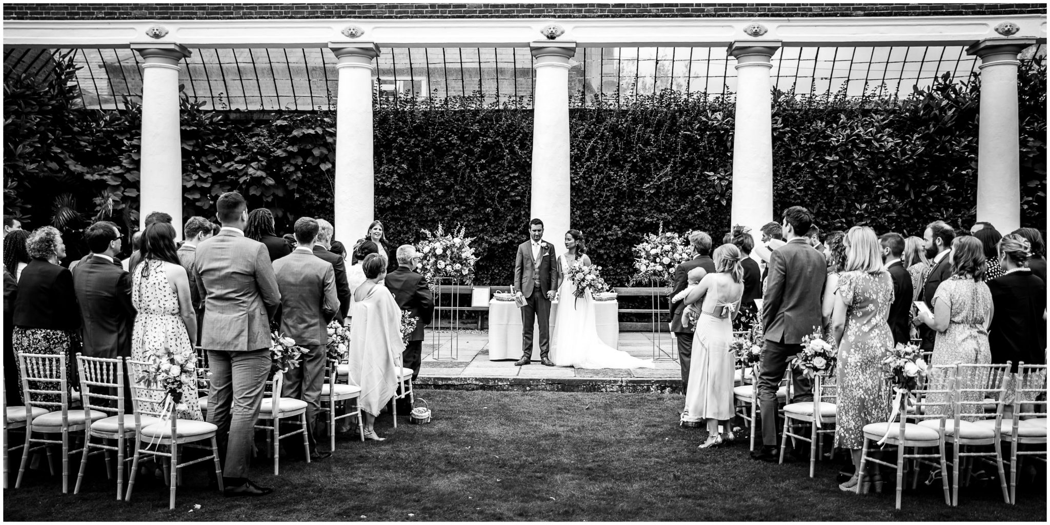 Black and white photo of bride and groom at the end of the outdoor wedding ceremony at Avington Park