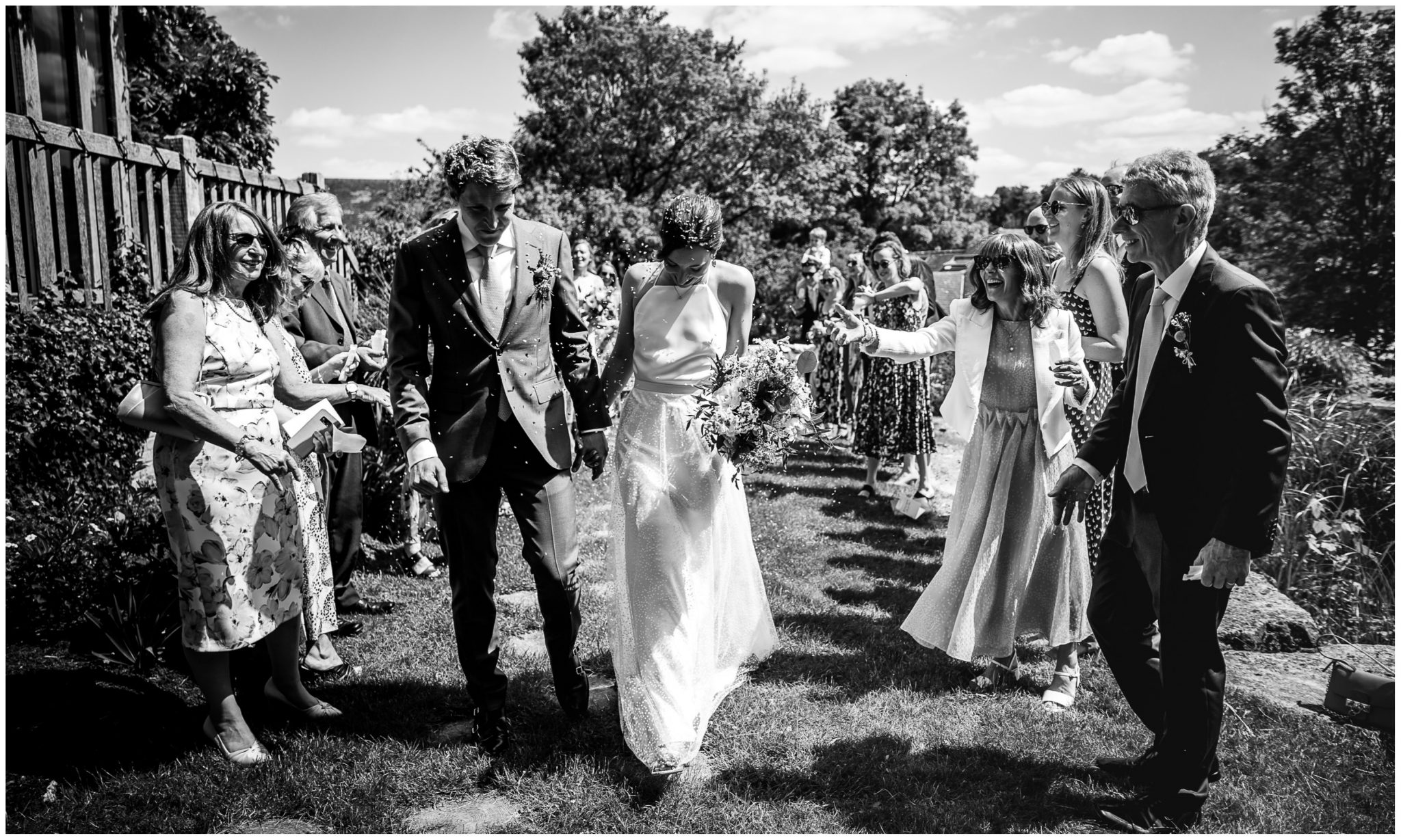 Guests throw confetti as the couple exit