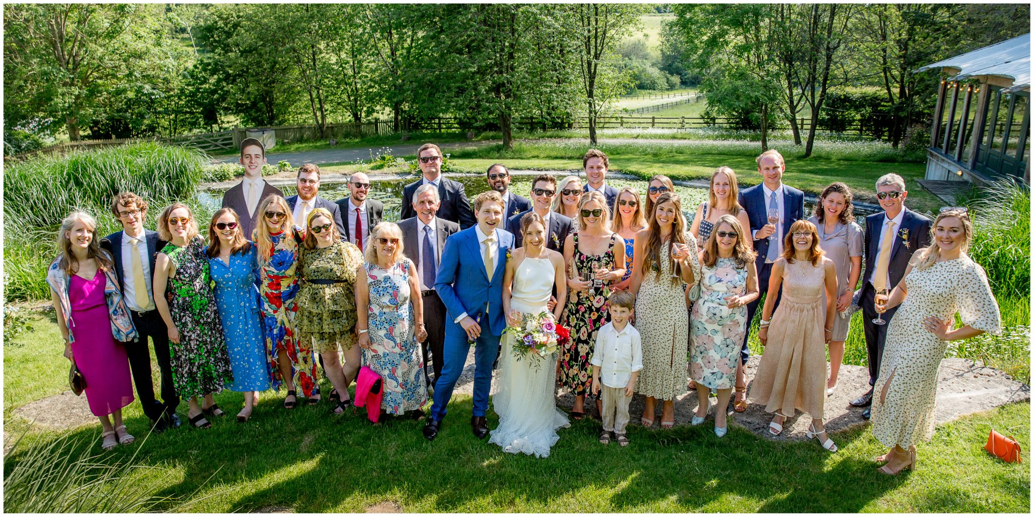 Group photo of all wedding guests in bright sunshine