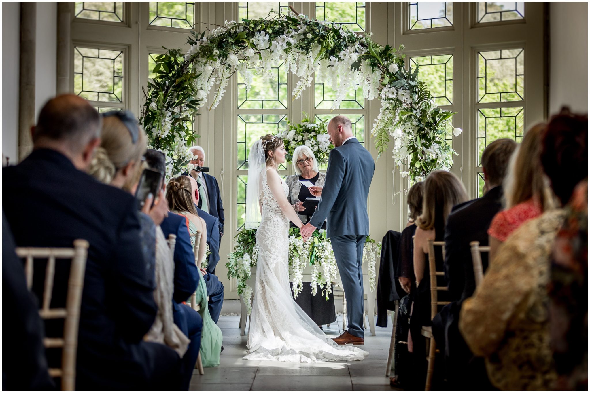 The couple framed by their floral arch as they make their vows