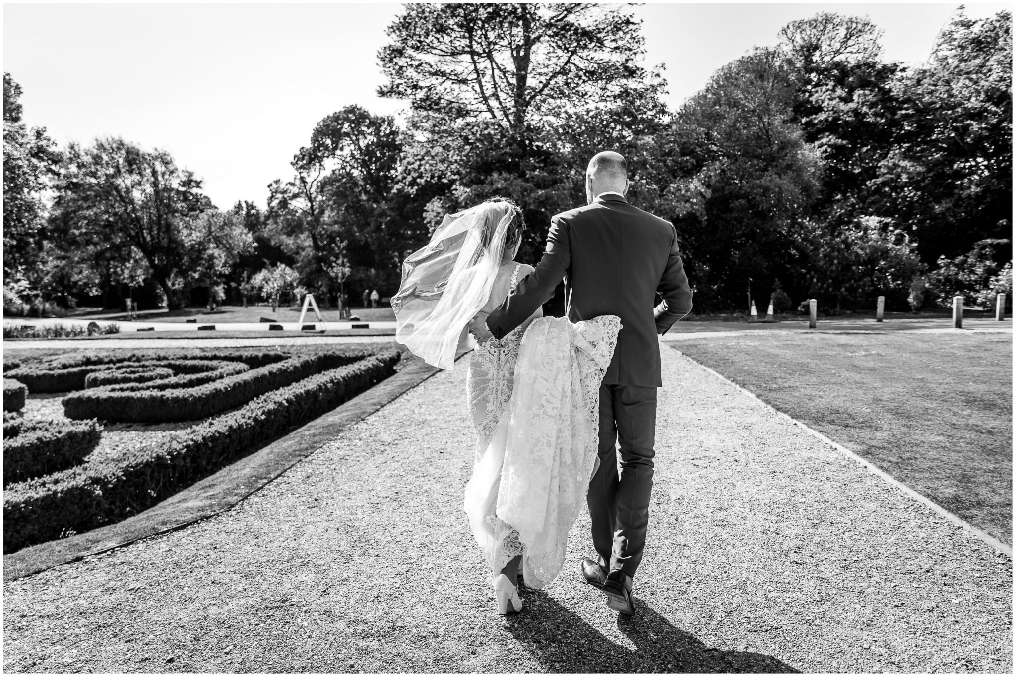 Black and white photo of courple walking away from the camera at Hampshire seaside wedding venue