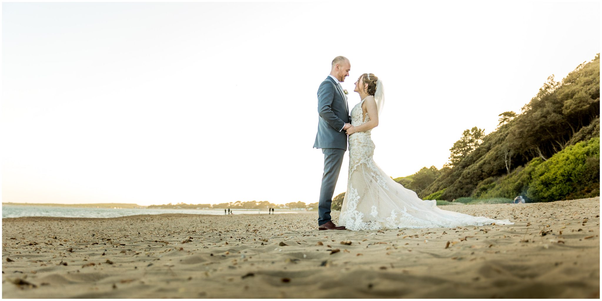 Bride and groom posing for couple portrait on the beach