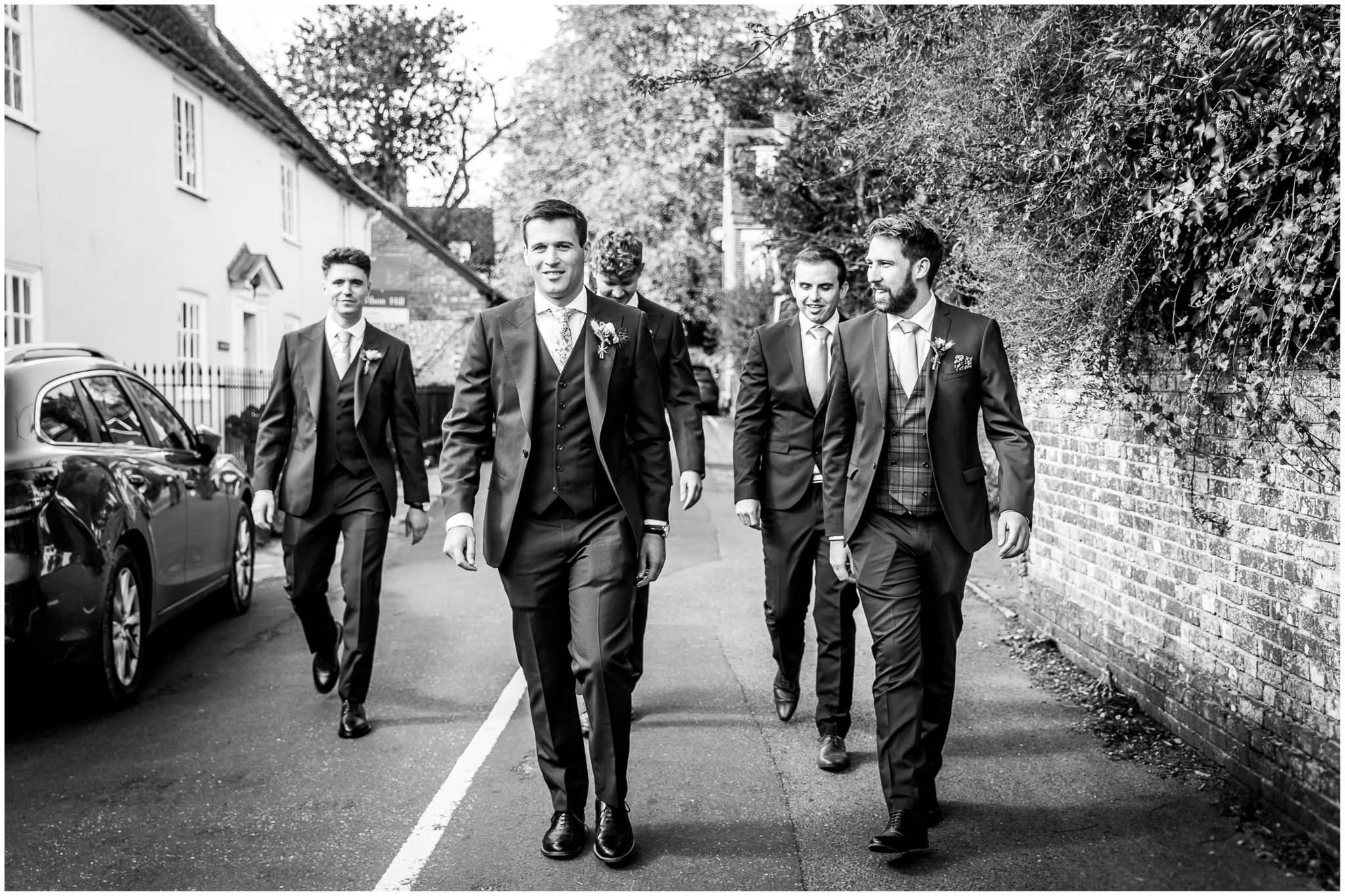 Groom and groomsmen walking through Droxford village to the church