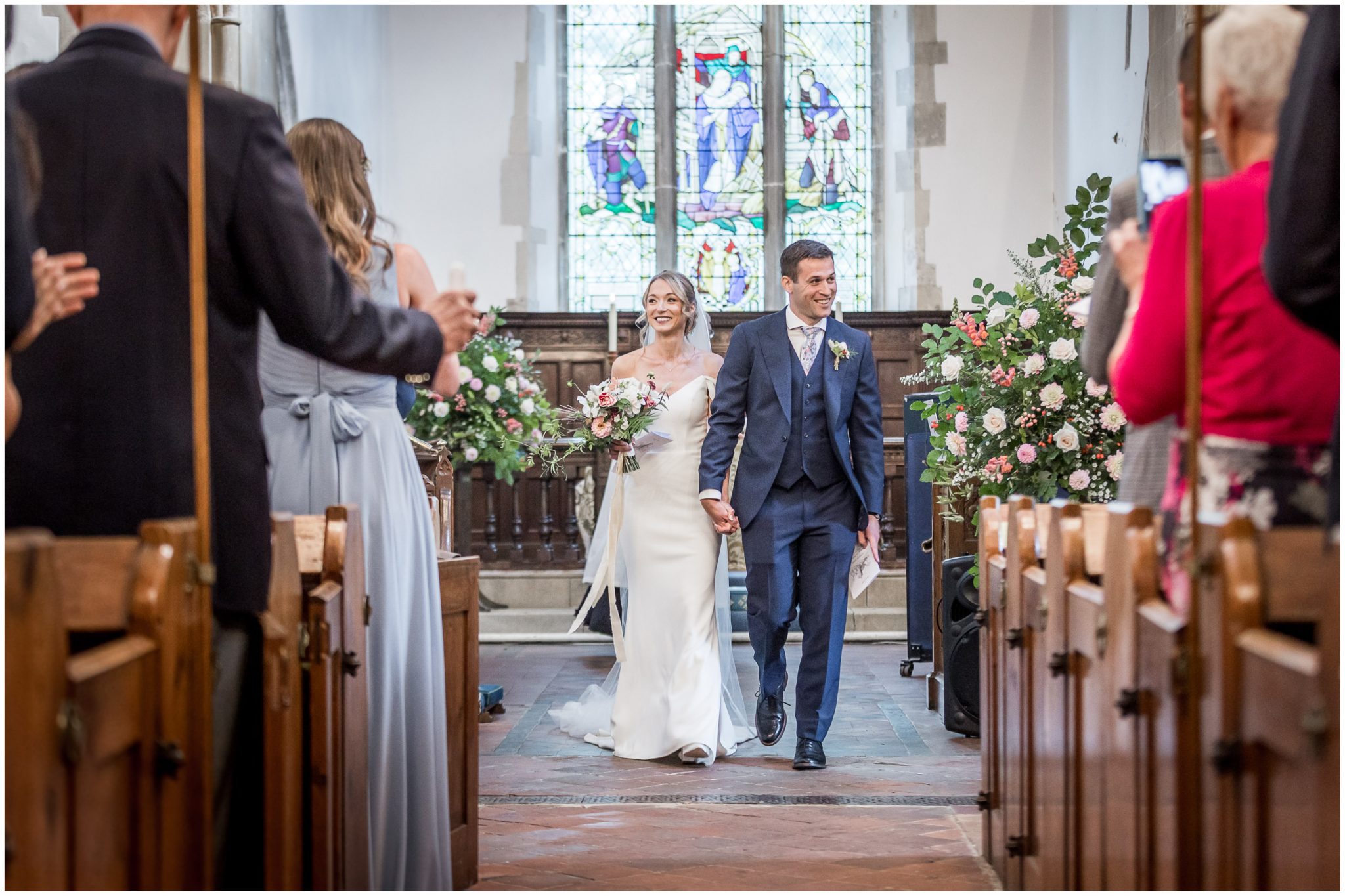 The newly married couple walk back down the aisle together as husband and wife
