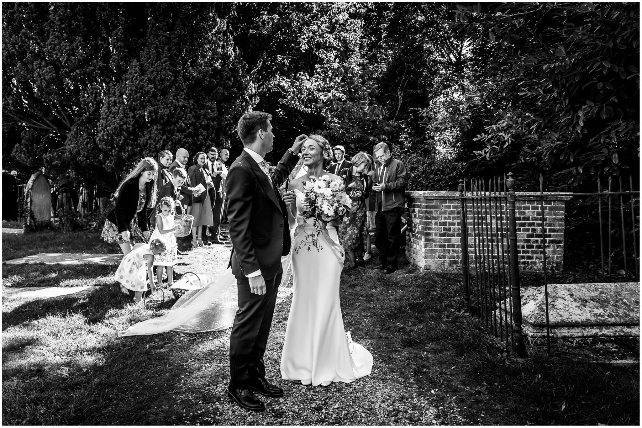 k and white photograph of bride and groom in church grounds immediately after the wedding