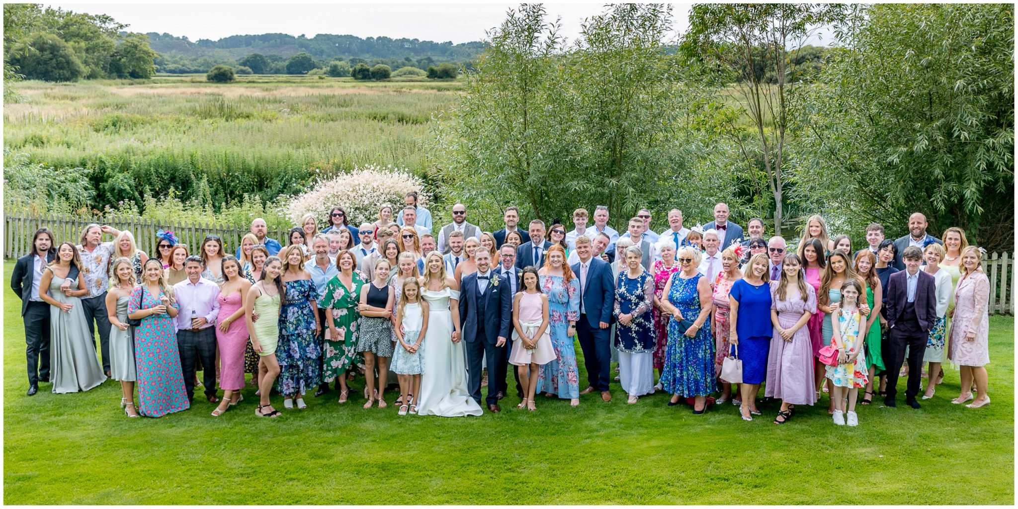 The group photograph of all guests with Dorset water meadows and countryside in the background