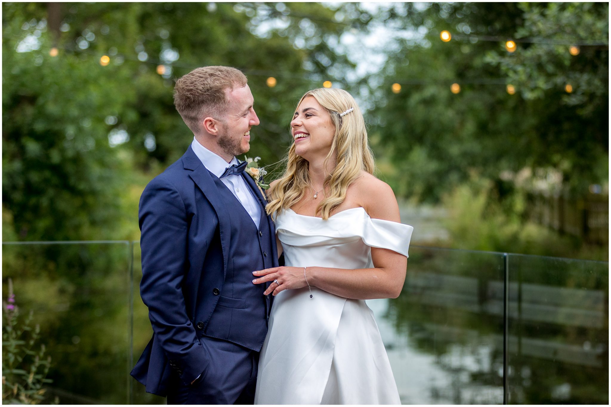 Colour photograph of couple by the river laughing
