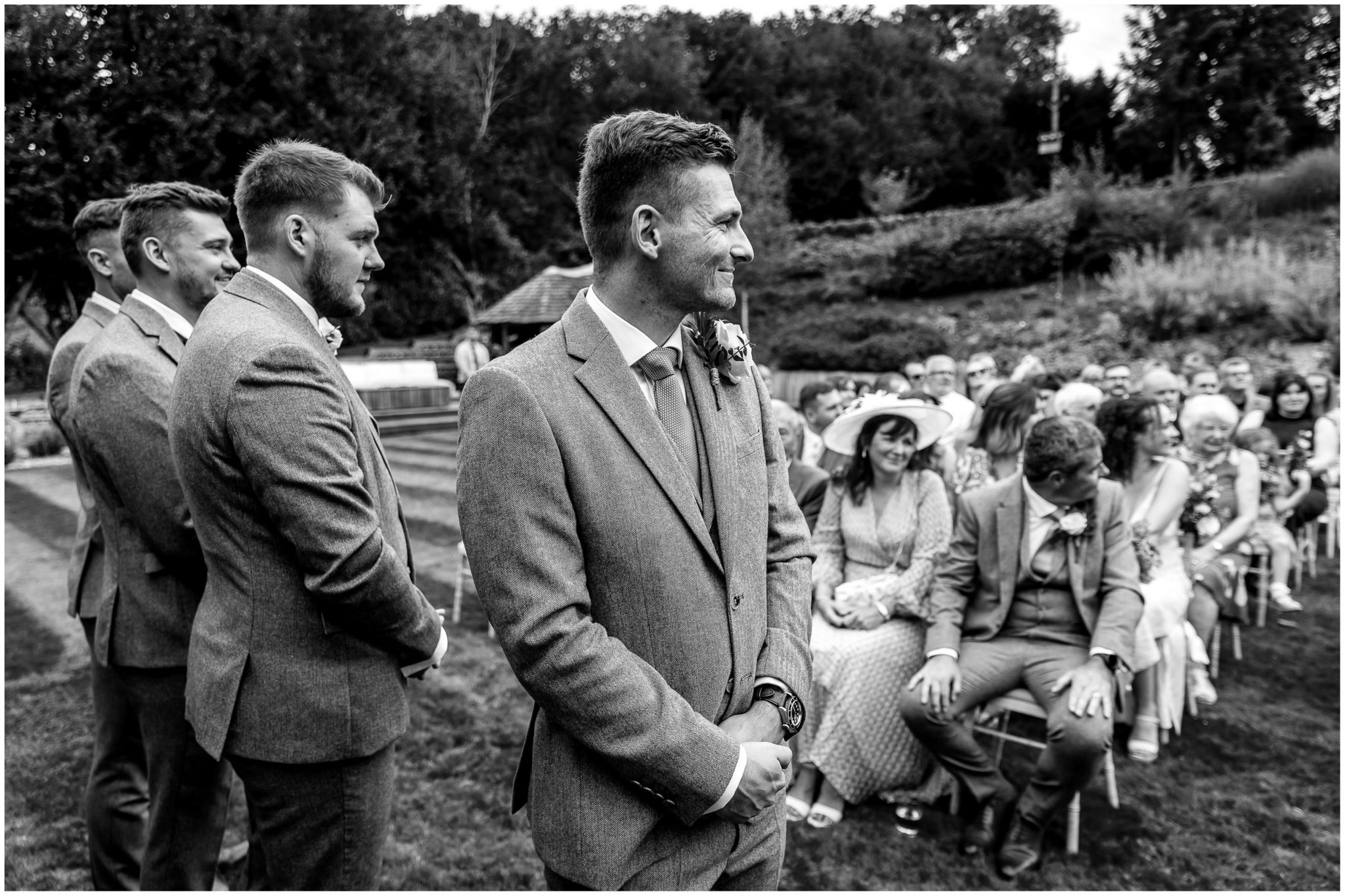 The groom watches as the bridal party walk down the aisle