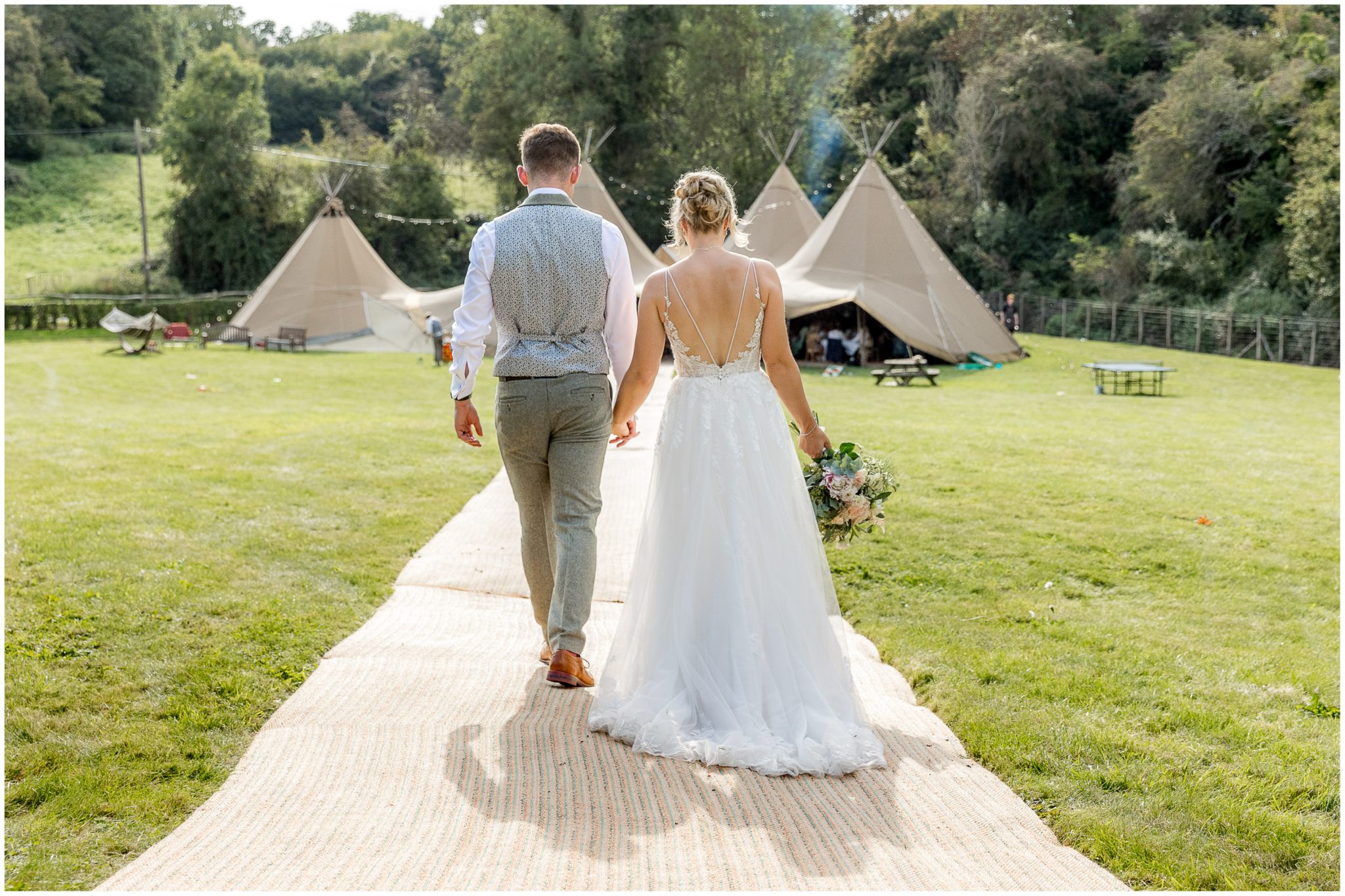 The couple head towards the tipi for the wedding breakfast