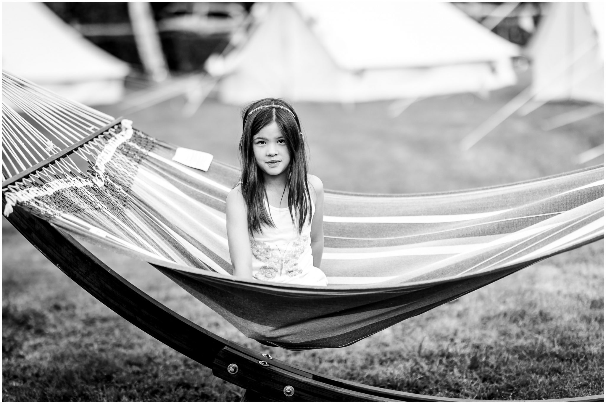 A young wedding guest sits in a hammock