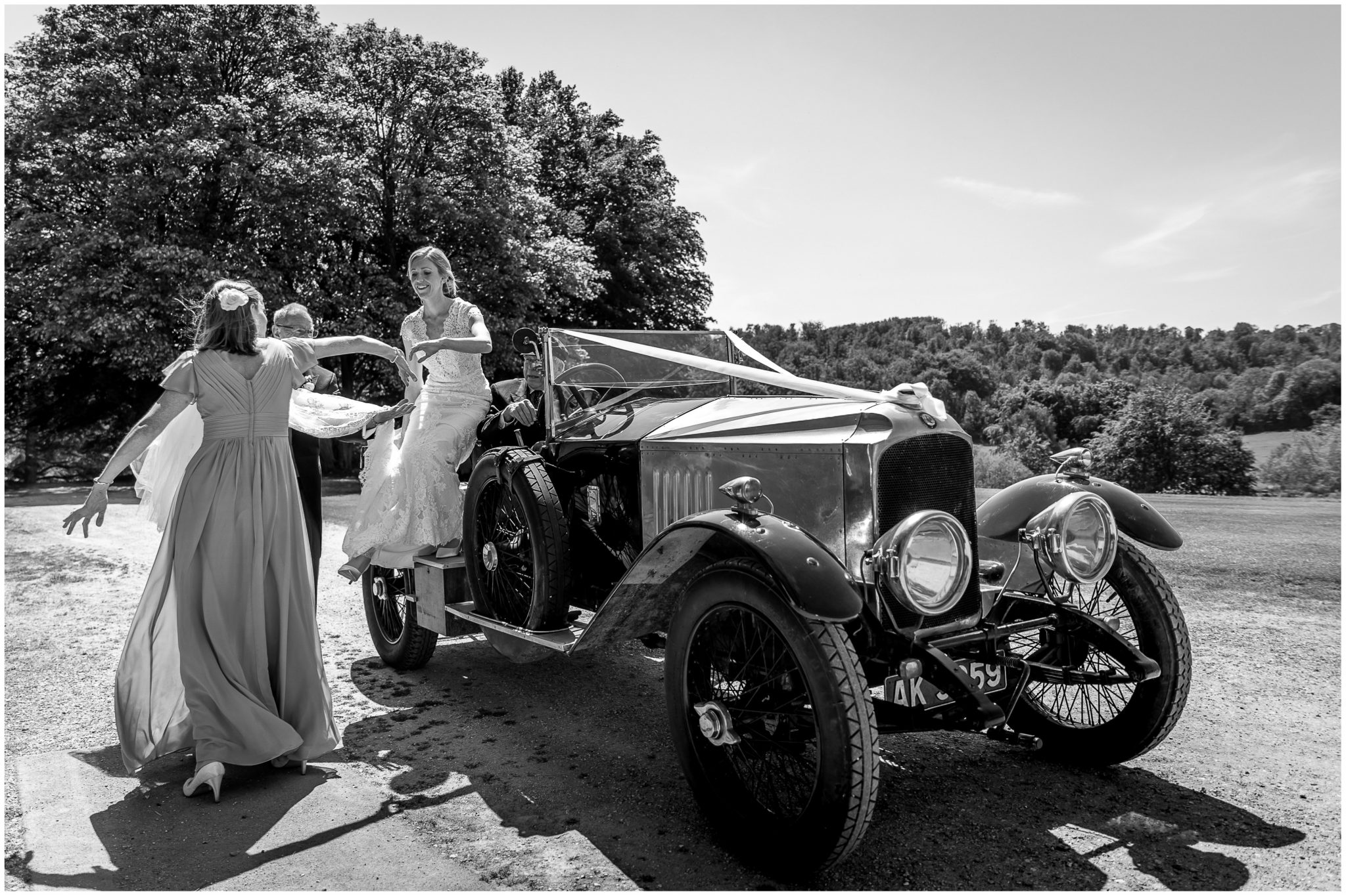 The bride arrives and steps out of the vintage wedding car