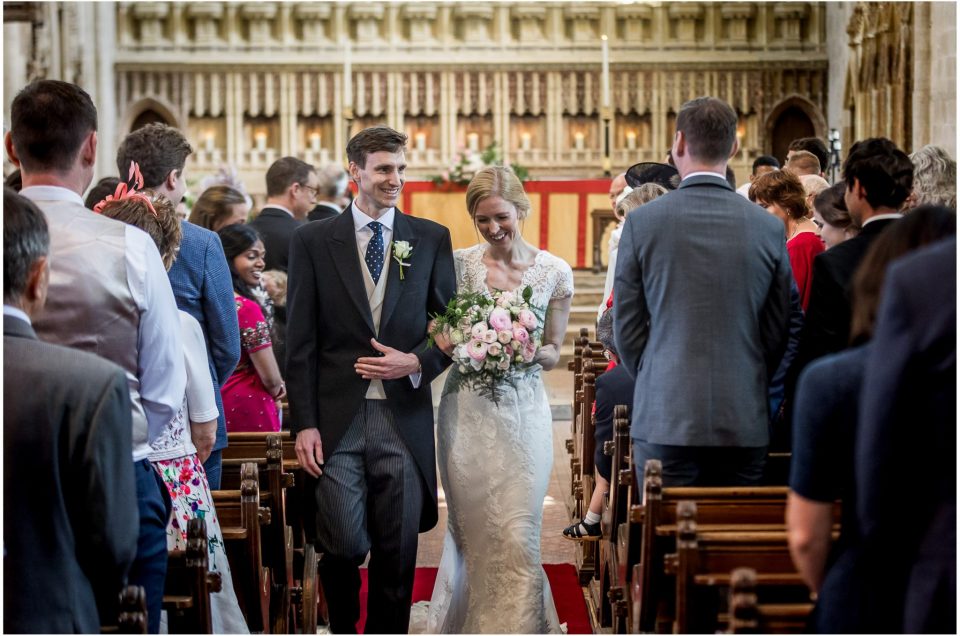 The newly married couple walk down the aisle together as husband and wife