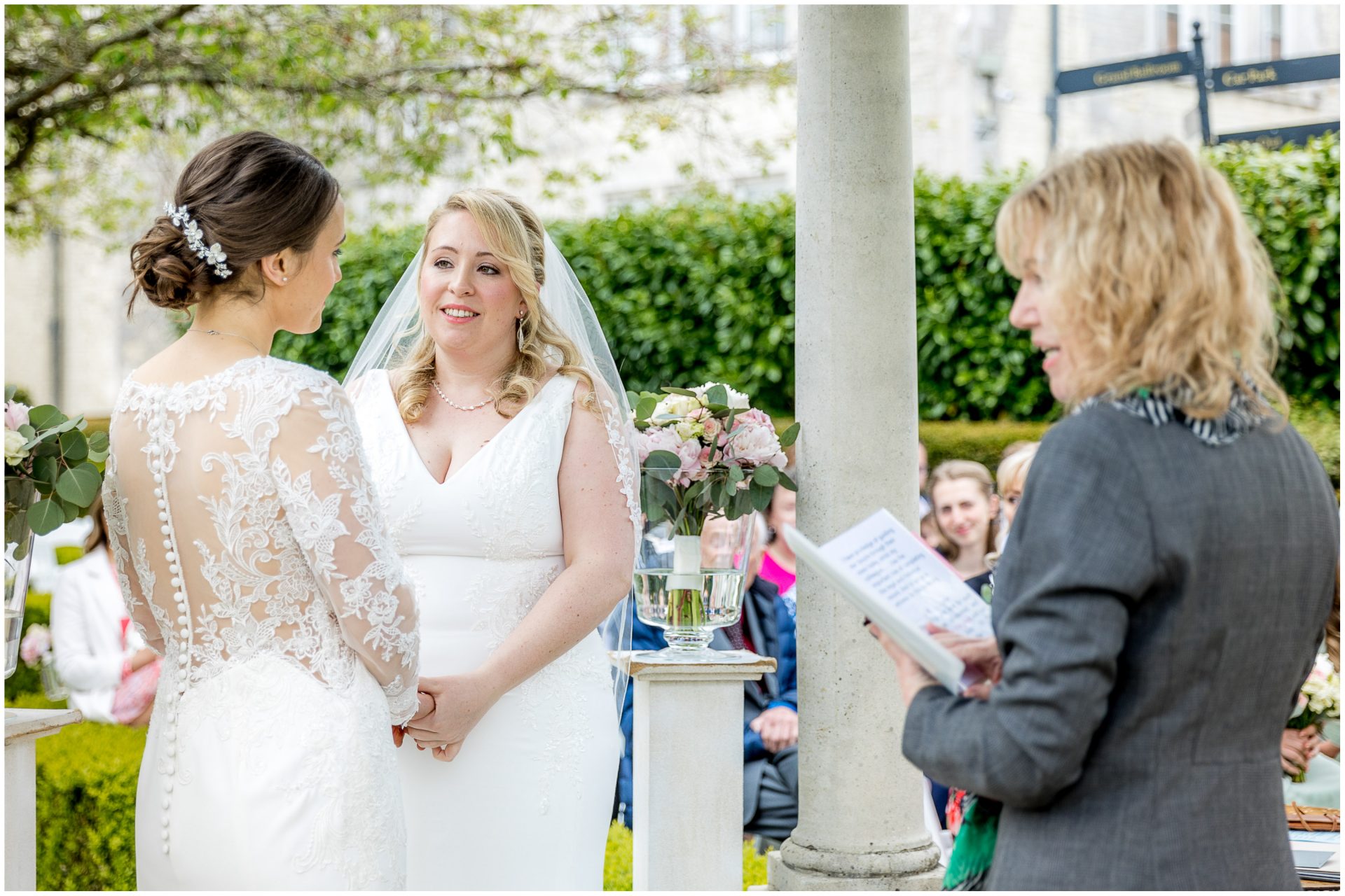 The two brides stand together at the start of the wedding ceremony
