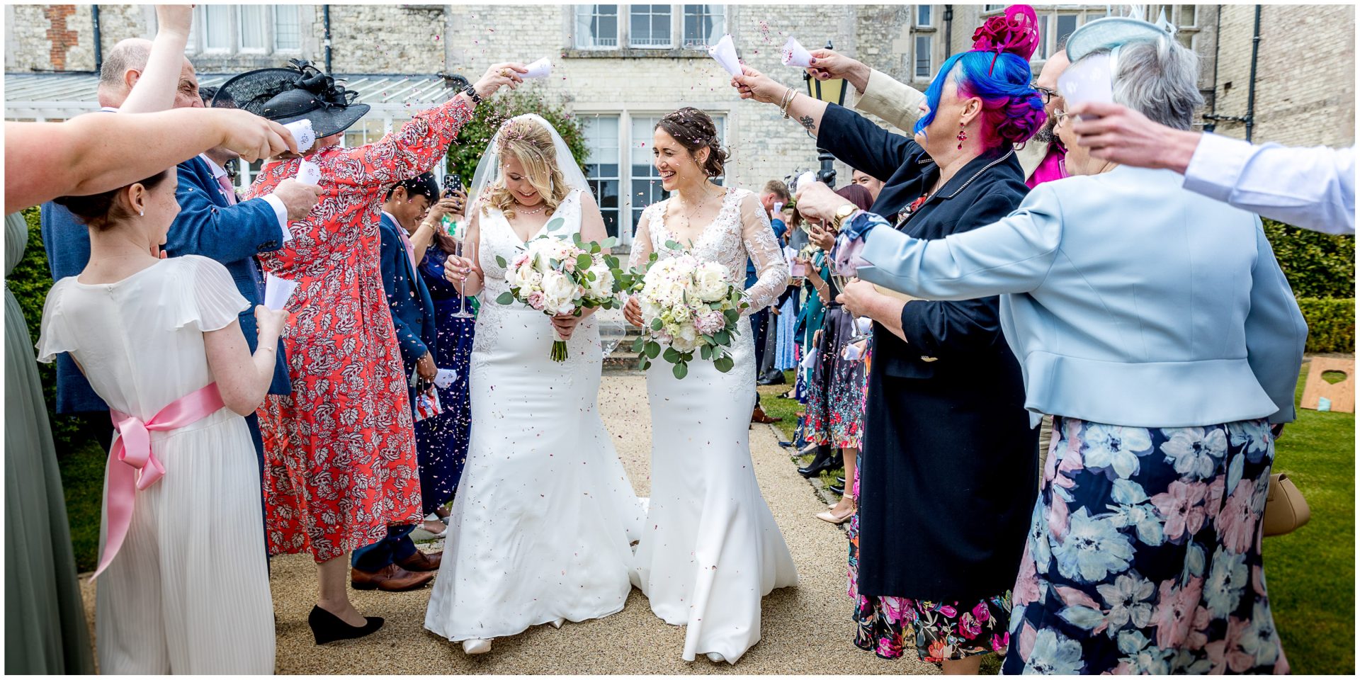 Wedding guests greet the couple with confetti
