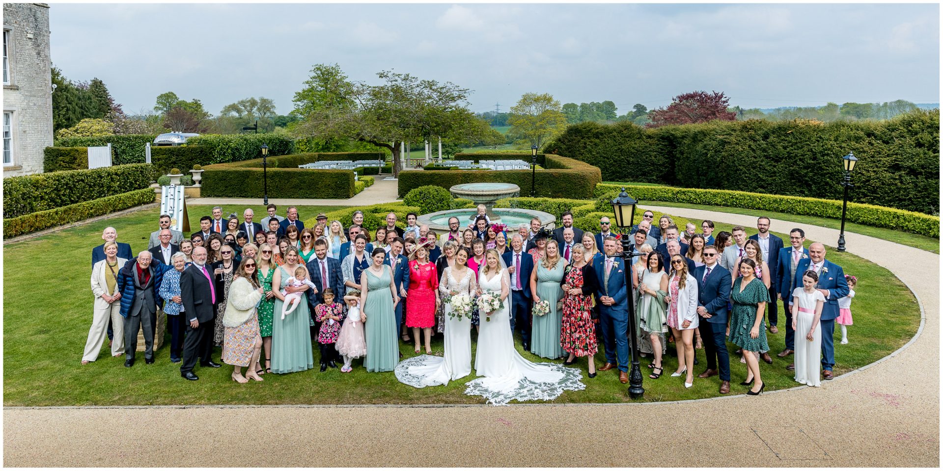 Group photo of all wedding guests in the gardens of Froyle Park Hampshire wedding venue