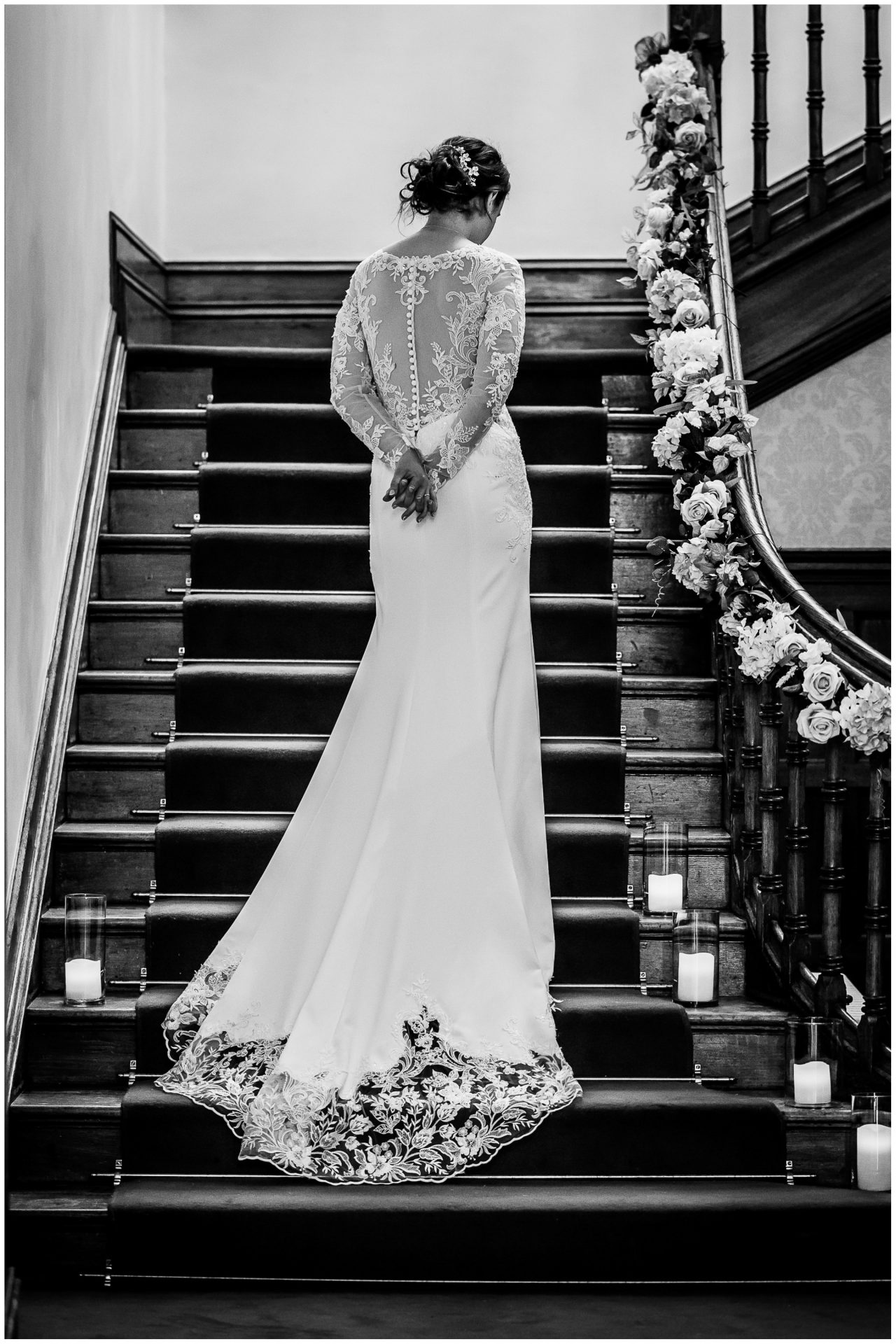 Portrait with detail of the back of the bride's dress on staircase in Hampshire manor house wedding venue