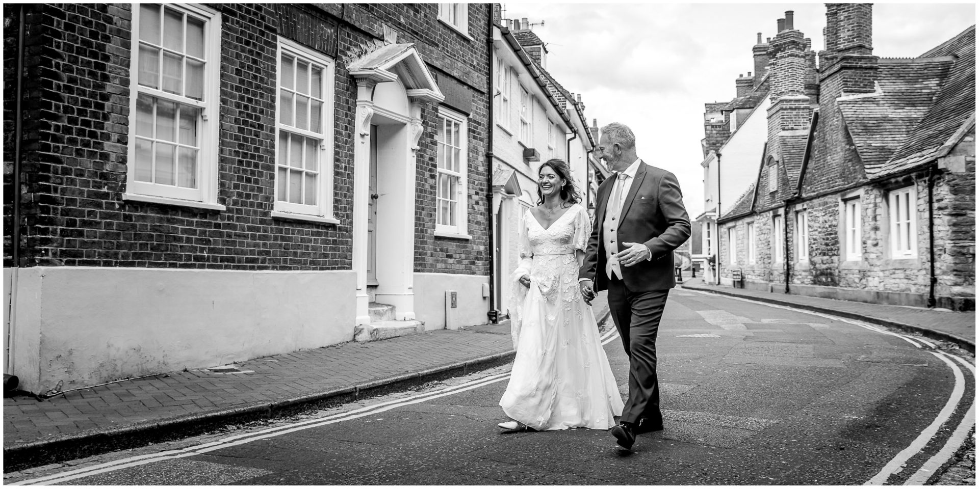 Black and white portrait of wedding couple walking through Poole old town